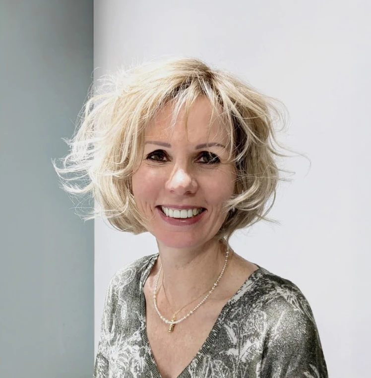 Intérieur lumineux d'un salon de coiffure professionnel avec tête d'entraînement blonde aux cheveux ondulés montés sur support doré