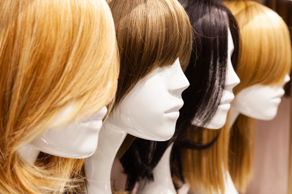 Mannequin de présentation féminin blanc portant une perruque blonde courte au carré avec frange, positionné sur fond neutre pour démonstration commerciale