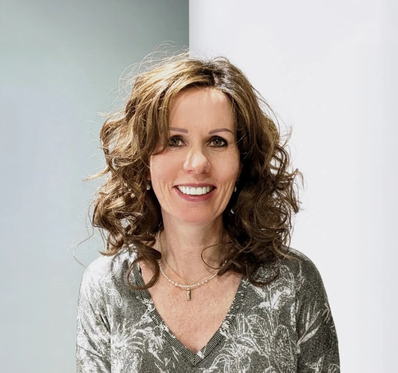 Femme examinant ses cheveux devant un miroir, touchant sa racine capillaire avec une expression préoccupée