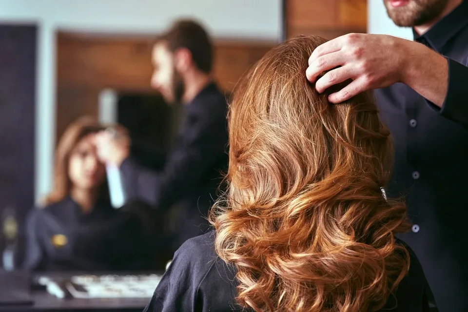 Salon de coiffure professionnel, coiffeuse travaillant sur une cliente assise