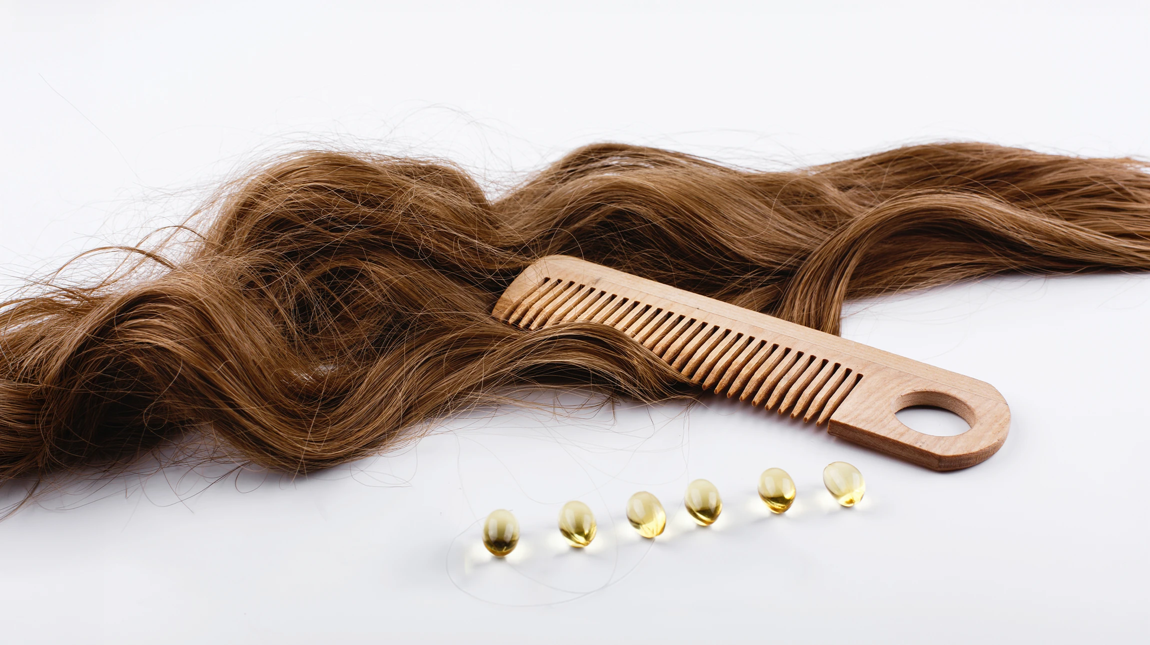 Gros plan sur une chevelure brune aux reflets cuivrés, mettant en valeur la texture lisse et soyeuse des cheveux