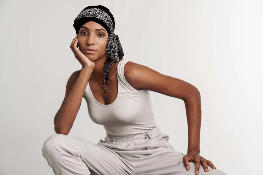 Femme souriante en intérieur sur fond blanc neutre, regard confiant et professionnel