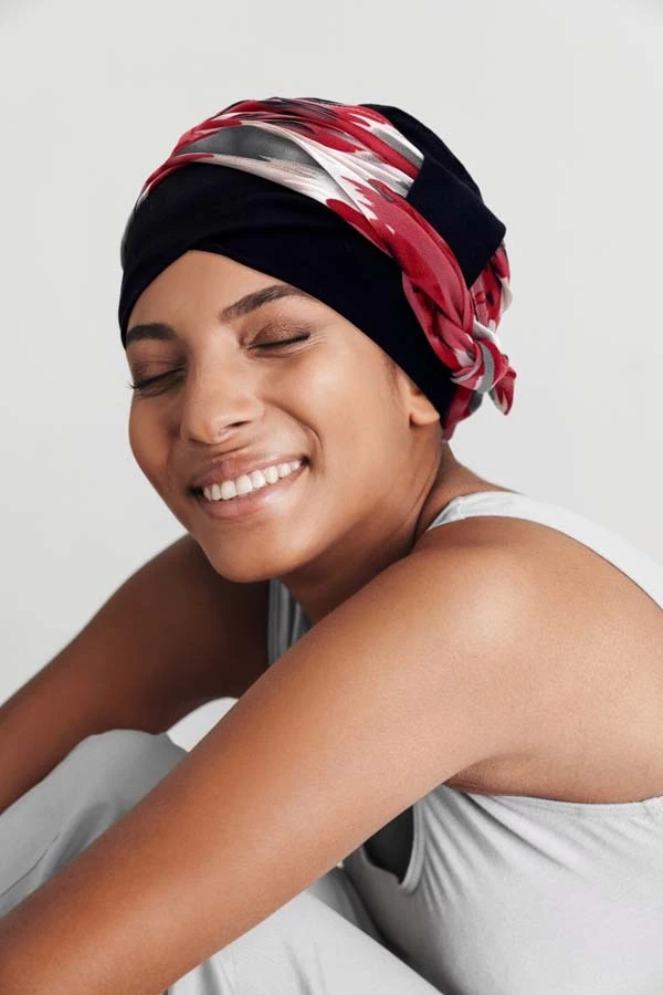 Femme souriante en intérieur sur fond blanc neutre, regard confiant et professionnel