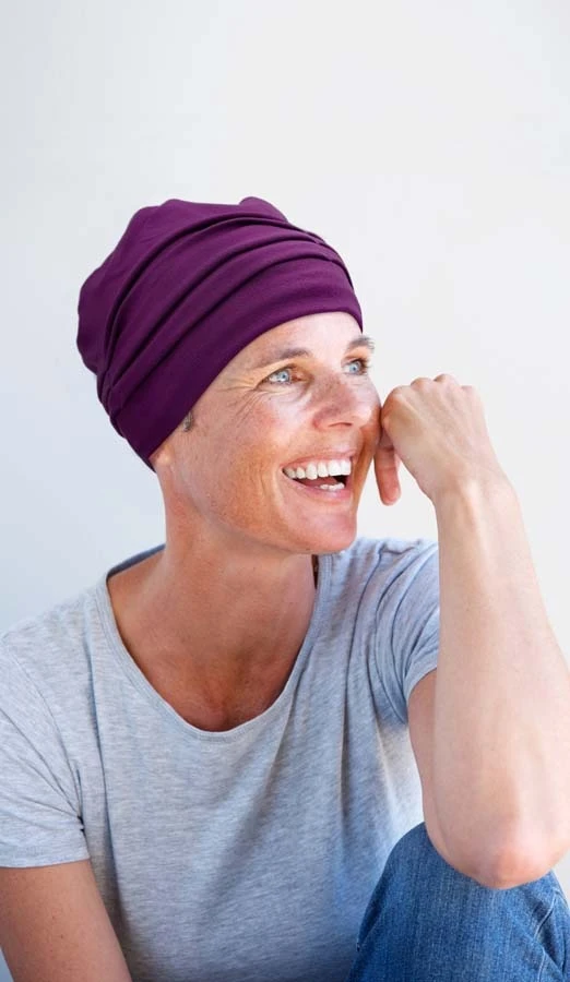 Femme souriante en intérieur sur fond blanc neutre, regard confiant et professionnel