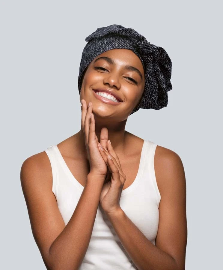 Femme souriante en intérieur sur fond blanc neutre, regard confiant et professionnel