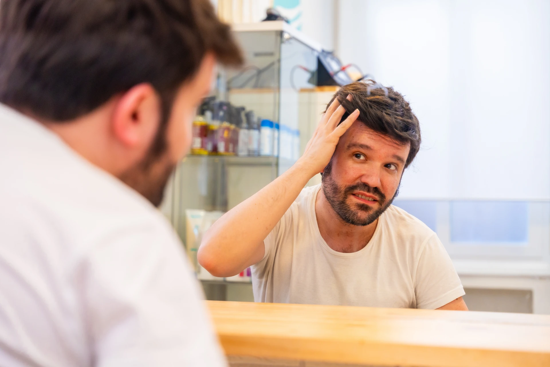 Une femme cosmétologue fait des modèles de sourcils pour l'homme par cire pour l'épilation