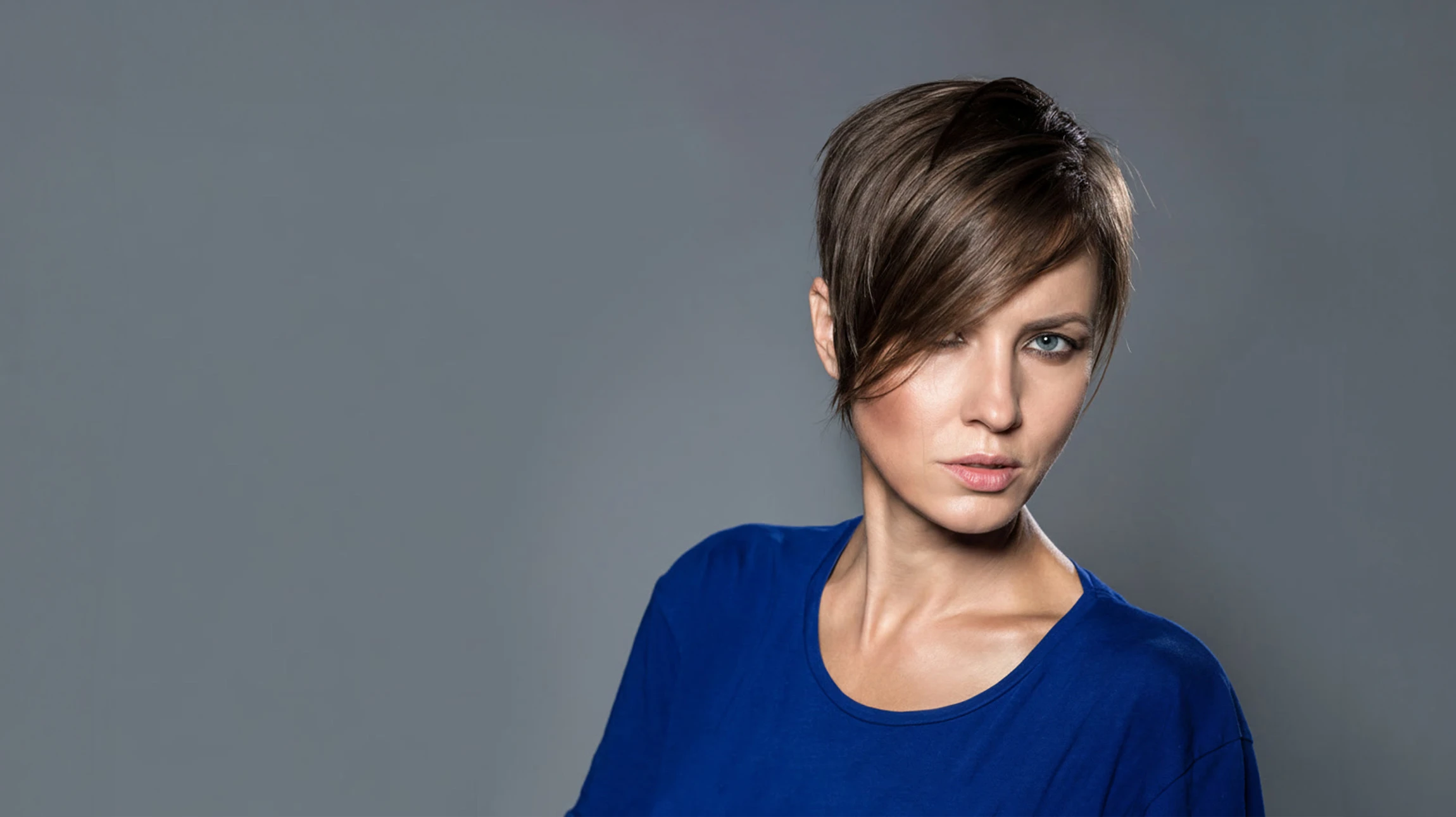 Scène intérieure avec deux femmes tenant délicatement une mèche de cheveux bruns ornée d'un ruban rose