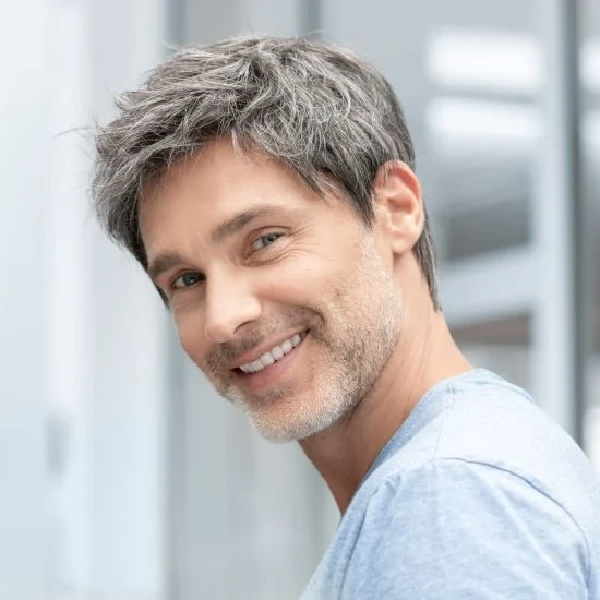 Femme souriante en intérieur sur fond blanc neutre, regard confiant et professionnel