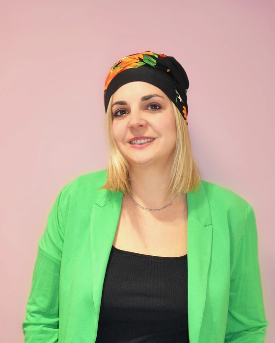 Femme souriante en intérieur sur fond blanc neutre, regard confiant et professionnel