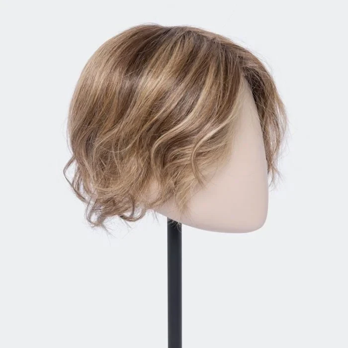 Intérieur de salon de coiffure avec cliente assise dos tourné, cheveux blonds mi-longs aux boucles voluptueuses fraîchement coiffées