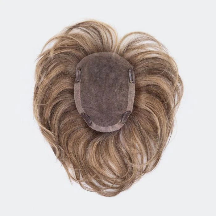 Femme souriante en intérieur portant un bandeau coloré à motifs floraux et un top noir à épaules dénudées