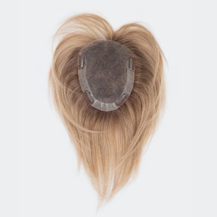 Femme souriante en intérieur portant un bandeau coloré à motifs floraux et un top noir à épaules dénudées