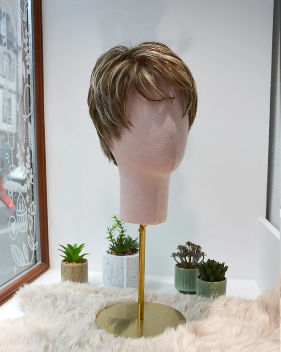Femme souriante en intérieur sur fond blanc neutre, regard confiant et professionnel