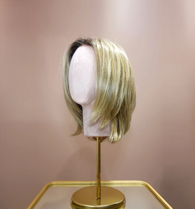 Femme souriante en intérieur sur fond blanc neutre, regard confiant et professionnel