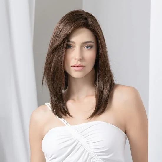 Femme souriante en intérieur sur fond blanc neutre, regard confiant et professionnel