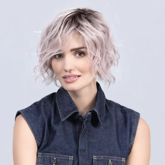 Femme souriante en intérieur sur fond blanc neutre, regard confiant et professionnel