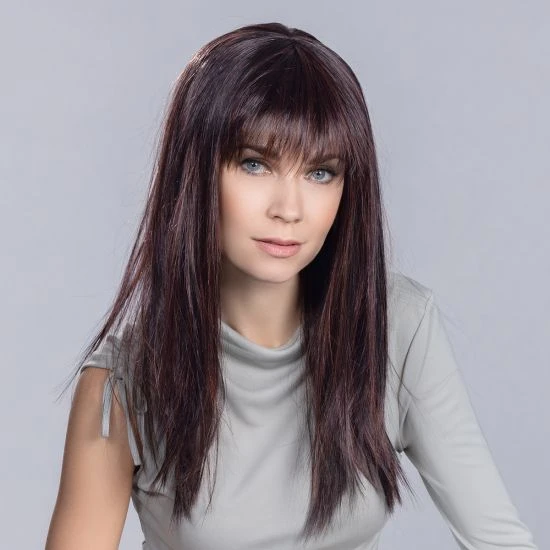 Femme souriante en intérieur sur fond blanc neutre, regard confiant et professionnel