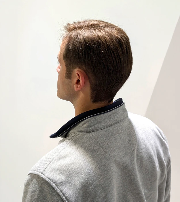 Femme souriante en intérieur portant un bandeau coloré à motifs floraux et un top noir à épaules dénudées